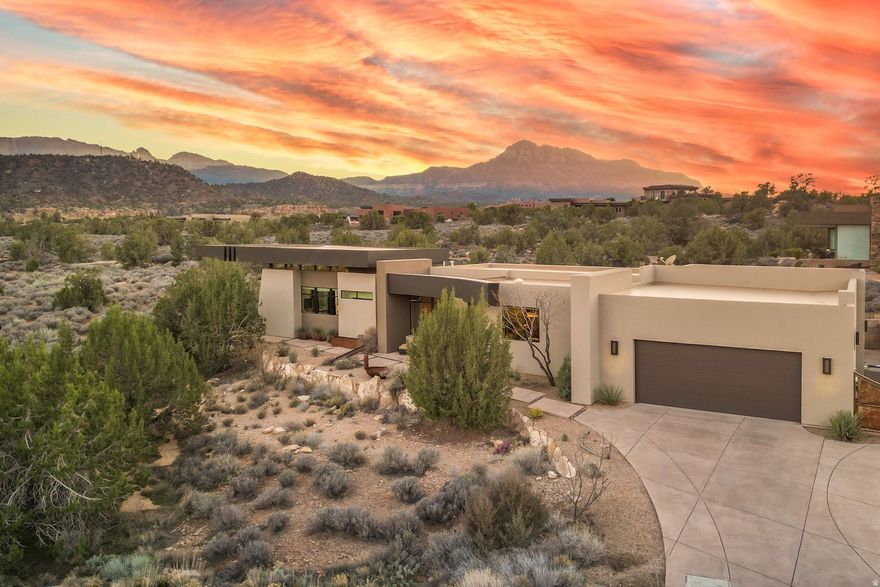 Located in the highly desirable Anasazi Plateau neighborhood just minutes from Zion National Park, this Burke Cartwright-designed home transforms the rugged Utah landscape into a private gallery. Every inch of this modern sanctuary is designed to honor its surroundings, with massive panes of glass framing iconic vistas of the West Temple and Kinesava red cliffs like living works of art. The interior radiates effortless warmth, anchored by light-toned engineered wood floors and an open-concept layout that flows naturally toward a sleek gas fireplace. Retreat to the primary suite to find your own gateway to the high desert, where a private backyard offers front-row seats to the glow of Eagles Crag. For guests or creative endeavors, the second bedroom functions as a self-contained suite featuring a built-in coffee bar, sink, and mini-fridge. Additionally, the oversized two-car garage goes beyond utility, offering a spacious workspace ideal for a professional studio or specialized storage. Rare, refined, and captivating-this is Zion living at its peak. Proof of funds required prior to showing.