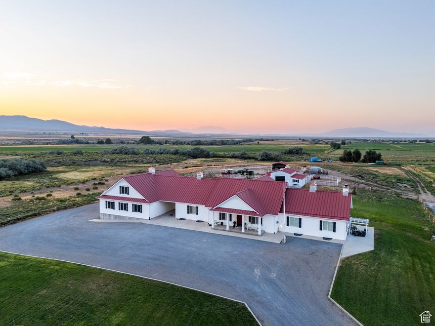 -- Country Ranch Retreat --  Kick the dust off your boots and come claim your slice of wide-open freedom. This true farmhouse sits on 48.4 acres of fertile ground with 360 views and the kind of water that makes ranchers grin. The private well supplies the home's culinary water, and you also get 15 irrigation shares for pastures, gardens, hay, and whatever you are brave enough to grow. Translation: extra water, excellent irrigation, real production potential.  Inside, the heart of the home is an expansive great room wrapped around a stunning stone fireplace. The kitchen is built for real life and big gatherings, with granite counters, gas cooktop, double wall ovens, double refrigerators, reverse osmosis, and serious storage. The owner's retreat delivers quiet luxury with dual vanities, a free-standing tub, a walk-in shower, dual walk-in closets, and its own cozy fireplace. In total you have 9 bedrooms and 5 baths, plus an office and quality finishes throughout. A full fire-suppression system adds peace of mind.  Work, store, and tinker to your heart's content in the 1,976 sq ft garage with an 884 sq ft finished bonus room above, two 1410 doors and one 1412 door, extra height and width, 110 and 220 power, and a tunnel to the basement mud room. Outbuildings include a matching barn with 4 stalls, a tack room, and feed storage with power. The property has been converted to natural gas, and utilities are dialed.  No cattle on site and no pasture lease in place, which means a clean slate for you. Bring horses, start a boutique cattle operation, plant alfalfa or specialty crops, add orchards or a market garden, raise goats or sheep, set up a U-pick, build an arena, run a retreat or wedding venue, family ranch compound (more building permits available) or lean into a full hobby-farm lifestyle. The possibilities here are varied and expansive.  Best of all, this is a rural retreat that keeps you close to everything. You are about 9 miles from I-15, so groceries, schools, healthcare, and everyday amenities are an easy run to town, then back to quiet skies and starry nights.  If you have been dreaming about land with real water, real infrastructure, and real elbow room, this is the one. Bring your vision. The gates are open.