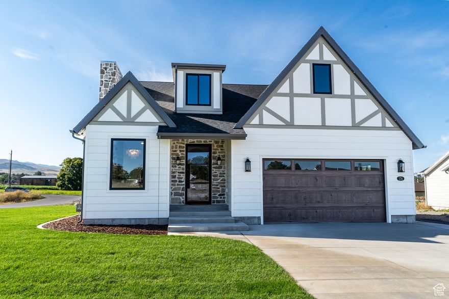 This Tudor-inspired, custom-built home-featured in the Top of Utah Parade of Homes-is packed with premium finishes, from high-end cabinetry and quartz countertops to quality flooring, premium appliances, and the thoughtful touches that make it truly special. From the moment you arrive, the elegant corner lot, striking arched front door, and beautifully designed entry foyer will captivate you. Inside, main-floor living offers both comfort and convenience, with the rock fireplace serving as the centerpiece of the open-concept living room. Every detail has been carefully curated, combining high-end craftsmanship with timeless style. Whether you're entertaining or enjoying quiet evenings at home, this residence offers the perfect balance of sophistication and warmth. Don't miss your chance to own a show-stopping home featured in one of the valley's most exciting home showcases!
