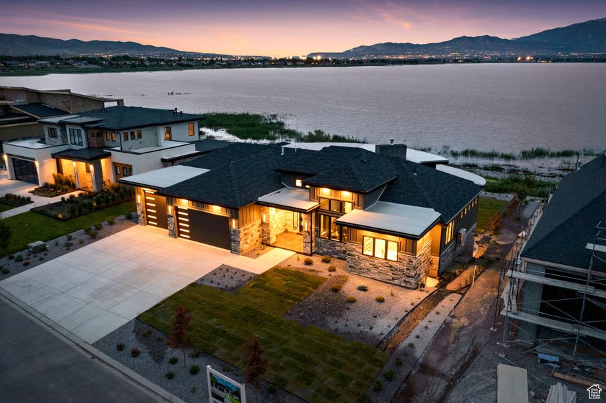 Lakeside Luxury home!!!  Enjoy east facing water and Mountain Views!  This stunning custom home offers sweeping panoramic views of Utah Lake and Mount Timpanogos, perfectly suited for the discerning buyer who values both luxury and tranquility. Enter through a grand custom glass door, where sophistication, elegance, and style await at every turn. The open, spacious floor plan is enhanced by soaring ceilings, beautiful beams, and large windows that frame breathtaking views, creating an atmosphere that's both welcoming and awe-inspiring. Highlights include a captivating floating staircase, unique architectural lines and curves, and designer finishes that reflect meticulous attention to detail. This home is truly a "MUST SEE IN PERSON" masterpiece, delivering an unparalleled waterfront retreat experience. Don't miss your chance to own this exceptional sanctuary where every element is designed to exceed expectations.   Square footage figures are provided as a courtesy estimate only and were obtained from county records.  Buyer is advised to obtain an independent measurement.