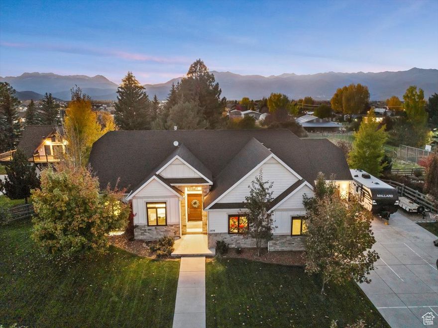 Stunning Heber Valley Retreat with Panoramic Mountain Views. Welcome to this highly desirable Heber Valley neighborhood, where breathtaking views of Mount Timpanogos frame this exceptional ranch-style home. Thoughtfully designed with a walkout lower level and an oversized garage-perfect for all your toys-this residence offers the best of mountain living with refined comfort. Step inside to find a highly upgraded interior featuring LVP wood flooring, vaulted ceilings, and a striking stone fireplace that anchors the inviting great room. The open floor plan seamlessly connects to a spacious dining area, ideal for gatherings and entertaining. The chef's kitchen impresses with new stainless steel double ovens, stylish cabinetry, a large island, granite countertops, a tile backsplash, and abundant natural light with stunning views. The primary suite offers tranquil mountain vistas and a luxurious spa-inspired bath. A main floor office, designer powder room with wallpaper and wainscoting, and a well-appointed mudroom with lockers add both style and functionality. New window treatments. The walkout lower level is filled with natural light and designed for entertaining-featuring a large movie-watching area, gaming space, gym, guest suites, and a gorgeous custom-tiled bath .Enjoy outdoor living at its finest on the flat, fully fenced yard with mature trees, a view deck, and a pergola patio-perfect for watching unforgettable Utah sunsets. Additional features include RV parking and ample storage throughout. Experience the best of the Heber Valley lifestyle, surrounded by world-class recreation, trails, lakes, and ski resorts-all in a community experiencing exciting growth and opportunity