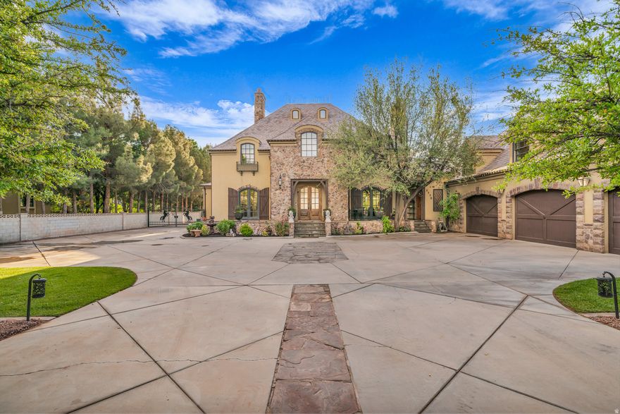 Seller Financing Available--Located in Bloomington Ranches, Southern Utah's most prestigious estate properties, this equestrian estate is truly unmatched. Set behind a private, secure gate on over 2 fully-fenced acres, it blends old-world European charm with modern luxury and exceptional privacy. The residence features imported stone fireplaces and flooring, stained glass accents, and expansive windows with views of the Virgin River and adjacent walking/bike path. Outdoor living shines with a sunset-facing patio and fully equipped outdoor kitchen. Built for a serious equestrian, the property includes a custom barn with 8 oversized European-style stalls, a professional riding arena, and 2 shares of irrigation water. Room for a pool, tennis or pickleball courts, or any outdoor adventure.