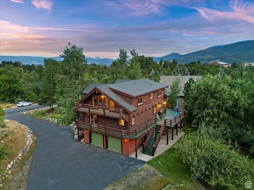 Welcome home to your romantic 3-bedroom Eden log-home retreat in the heart of the desirable Ogden Valley. From the moment you arrive, the wrap-around porch will capture your heart, perfect for taking in mountain views, spotting wildlife, and savoring the seasonal beauty all around. Step inside to the breathtaking Great Room with soaring ceilings, pristine log beams, a cozy gas stove, and walls of windows that fill the space with light and views. The open kitchen makes entertaining a joy, with everything a chef needs close at hand. Enjoy meals at the breakfast bar, in the bright dining nook, or out on the deck overlooking the open fields behind you. A convenient half bath is located just off the kitchen. Your main-floor Primary Suite is a private escape, with two walk-in closets, direct deck access, and a spa-like bath featuring a jetted tub, huge shower and dual sinks, providing space for two to prepare and end the day comfortably together. Upstairs, find two more generous bedrooms, a full bath, and an open loft with spectacular views, perfect for an office, reading nook, or play space. The finished basement offers a large family room with theater risers for movie nights, plus a bonus space ideal for a game room, craft area, or playroom. The oversized laundry room provides ample storage, and the oversized 2-car garage offers plenty of room for vehicles, gear, and workshop space. The semi-private 1/3-acre lot backs to permanently protected open fields via the Ogden Valley Land Trust, your views will never be obstructed. This move-in ready home boasts a newer roof (2020), all new high-efficiency windows (2023), a brand-new HVAC system (2025) with a transferable 10-year warranty, a radon mitigation system, and log restoration with new deck railings (2022).  All this in a sought-after neighborhood near three ski resorts, year-round fun on Pineview Reservoir, Wolf Creek Golf Course, and miles of hiking, biking, and horseback riding trails. Everyday conveniences-market, gas station, post office and restaurants-are just minutes away, with even more in Ogden only 20 minutes further. Whether you're looking for a full-time residence or a vacation getaway, experience peaceful, beautiful living close to nature and away from the crowds. Call today for your private tour.
