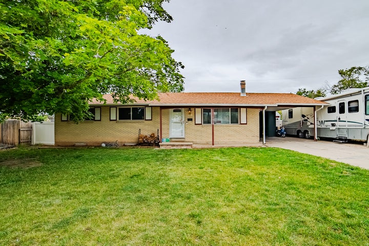 Ranch-style exterior with brick siding, a covered entry, and an attached carport