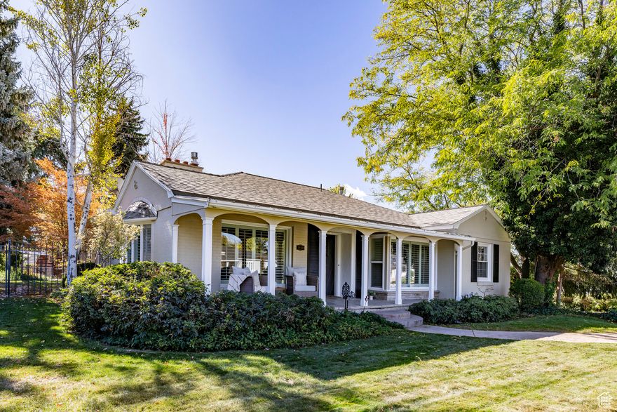 Here is a home with all the charm of an experienced host, the cheerfulness of a sunny day, the compactness of a Pullman, and the lasting appeal of a lovely painting. These words were first written by Joyce Evans in the Deseret News in July of 1948, when this home was featured in the Salt Lake Parade of Homes, and her description still fits beautifully today. Situated on a gentle slope with a rock wall and flat lawn this Georgian residence continues to carry a graceful spirit and a welcoming presence. A pillared veranda, white painted brick exterior with black shutters, ample windows, and a paneled recessed front door create a timeless and carefully composed facade. Inside, there is an immediate sense of welcome. The living room remains comfortable and inviting, with built in bookcases, a generous bay window, and a warm hearth that has anchored gatherings across generations. The kitchen has been thoughtfully updated with marble countertops, stainless steel appliances, and white cabinetry, opening into a bright rear addition with abundant windows overlooking a beautifully landscaped yard with mature trees and room to enjoy outdoor living. The garage accommodates four cars in a tandem layout, two wide with extended depth for two more vehicles. A concrete pad behind the garage and an additional storage shed provide room for outdoor gear, gardening tools, or recreation equipment. This property has been preserved with care and appreciation for its history, character, and architectural charm by the current owners. The home lives comfortably on its lot with pleasant outlooks and an ideal location with quick routes to the nearby canyons for recreation, close to schools, Holladay and Millcreek town centers, convenient access downtown Salt Lake City, the University of Utah, and to the airport.