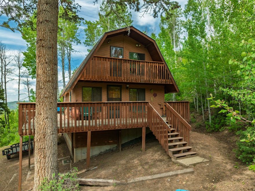 Thoughtfully priced to reflect the opportunity for buyers to bring their own vision and enhancements, creating a truly personalized mountain retreat. Some properties are simply purchased and others are experienced, cherished, and ultimately stewarded.  Welcome to Lot #34 in the gated mountain enclave of Causey Estates, where a rustic barn-style cabin rests quietly among quaking aspens and towering pines, overlooking the pristine waters of Causey Reservoir. This 1-bedroom, 1-bath retreat with an open loft and unfinished basement offers both immediate enjoyment and the opportunity to thoughtfully expand or customize. With power and spring water already in place, the foundation is set for creating a legacy mountain escape tailored to your vision. Here, the rhythm of life slows. Mornings begin with crisp alpine air and panoramic views, while days are spent exploring miles of surrounding wilderness-hiking, paddleboarding, fishing, snowmobiling, or simply observing the abundant wildlife that calls this area home. Evenings invite connection, reflection, and a sky filled with stars. Located just 20 minutes from Huntsville and under an hour from Ogden, this private mountain setting offers a rare blend of accessibility and true seclusion. Nearby amenities include Monte Cristo recreation areas, extensive trail systems, and renowned skiing at Snowbasin and Powder Mountain, along with summer recreation at both Causey and Pineview Reservoirs. Winter access is limited to tracked vehicles, preserving the peaceful, untouched beauty of the season. Whether you envision a quiet personal retreat or a long-term investment in one of Northern Utah's most scenic gated communities, this property offers an exceptional opportunity to create something meaningful and lasting. Please note: Property is not zoned for nightly rentals. Square footage figures are provided as a courtesy estimate only and were obtained from county records. Buyer is advised to obtain an independent measurement.