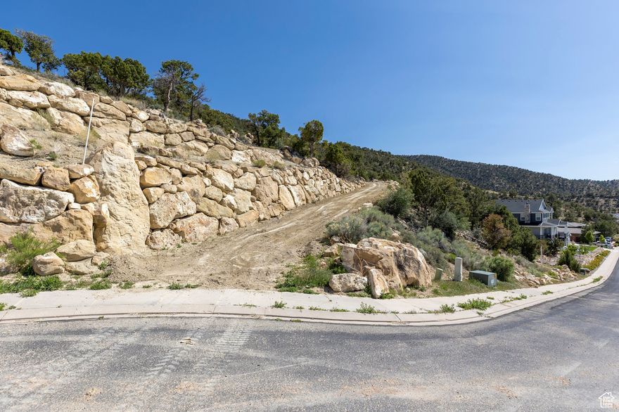 Set at over 6,100 feet in elevation, this is one of the highest-and most scenic lots in Cedar City. Located in the peaceful Ashdown Forest subdivision, this 2-acre pad-ready wooded property offers incredible views of the Cedar Valley and surrounding mountains. The lot features private hiking and deer trails, natural overlook points, and a peaceful setting perfect for evening walks. It's also less than 1,000 feet from the public trails in Fiddlers Canyon, offering some of the area's best nature walks right out your door. The land has been thoughtfully improved, with multiple cleared and excavated areas ideal for a greenhouse, garden, workshop, or detached garage. A home site pad has already been cut, with minimal fill used and good soil compression, making it easier to start your build. Take a drive up the private road to the top of the property and take in the views-it's a location that truly needs to be experienced in person. HOA approved Building Plans available for a 4,700 SqFt home with mostly main level living and up to 5 car garage.  Cedar City is one of the most beautiful cities. It is home to Southern Utah University and the Shakespeare Festival, as well as some amazing restaurants. As part of Southern Utah, you will experience a lifestyle like no other. The area features nearby internationally recognized mountain biking trails, road cycling, hiking, golf courses, national parks such as the Grand Canyon, Zion, & Bryce, national moments, national forest, reservoirs, & some of the most iconic desert landscapes in the world. Less than an hour away from Brian Head Ski Resort, there is no doubt that this is a fun place to live and play.  All information herein is deemed reliable but is not guaranteed. Buyer is responsible to verify all listing information, including square feet/acreage, to the buyer's own satisfaction.