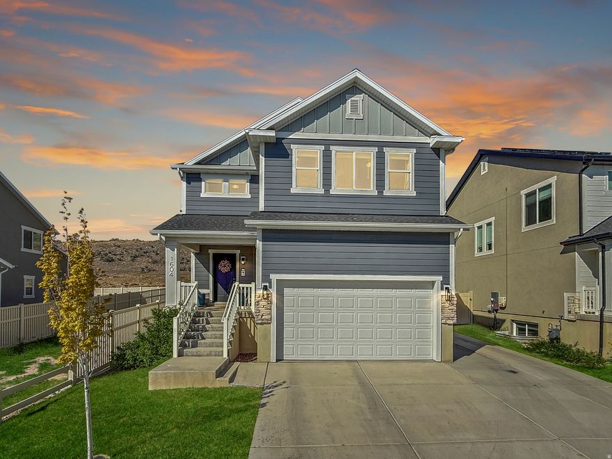 Tucked into a quiet Saratoga Springs neighborhood with no backyard neighbors, this thoughtfully maintained two-story home offers a bright, open layout paired with functional upgrades and rare privacy. Backing to a large hillside instead of another row of homes, the backyard feels far more secluded and peaceful than many nearby properties. Inside, the home immediately opens up with an airy open-to-below great room filled with natural light from expansive windows throughout the home. The open handrail staircase and loft design further enhance the spacious, elevated feel, while the layout flows naturally for both everyday living and entertaining. Upstairs, the vaulted primary suite serves as a comfortable retreat, featuring a large walk-in closet, dual vanity, enclosed toilet room, separate glass shower, and a soaking tub. The home's abundance of windows continues throughout the upper level, creating a warm and inviting atmosphere across the entire home. The fully finished basement was completed within the last year and adds significant additional living space, including a large rec room currently set up as both a theater area and kids' play space. You'll also find an additional bedroom and bathroom downstairs, with the bedroom currently functioning as a home gym, along with added storage space that was thoughtfully incorporated during the basement finish. Outside, the backyard patio was expanded with additional concrete to accommodate a future hot tub setup, with the current hot tub negotiable. Along the side of the home, extra concrete parking and a gated fence access provide additional flexibility for storage, trailers, or easier backyard access. The garage also features extra vertical clearance for overhead storage and already includes two mounted storage racks, with room to add even more. Built in 2019 and owned by the original owners since construction, this home blends the advantages of newer construction with meaningful upgrades already completed. Conveniently located near golf courses, city parks, grocery and retail shopping, and highly rated schools, the surrounding neighborhood also offers access to hiking and biking trails, pickleball courts, playgrounds, picnic areas, and large open grassy common spaces that make it easy to enjoy the outdoors and connect with the community. Schedule your showing today! Square footage figures are provided as a courtesy estimate only and were obtained from the building plans. Buyer is advised to obtain an independent measurement.