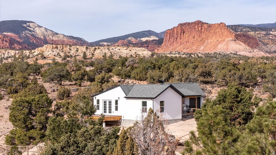 NEXT TO NATIONAL FOREST!  The entire Thousand Lake Mountain is out the back door of this very pleasant, light-filled home on the edge of Sleeping Rainbow Estates. An incredible view in all directions is just one of the attributes of this property. Overlooking Sand Creek provides endless opportunity to watch birds and wildlife that travel from the National Forest along the stream. With 2 bedrooms, 2 baths and an open floor plan, the home makes good use of space that allows for convenience and comfort. Glass French doors leading to the sizable deck on the south add light and views of Boulder Mountain. Energy efficiency is a plus with three mini-splits and a pellet stove. An attached garage provides storage as well as a garden shed. Tall pinions provide shade for an outdoor sitting area. The home has been completely and thoughtfully remodeled with an addition. All appliances are included. City water.