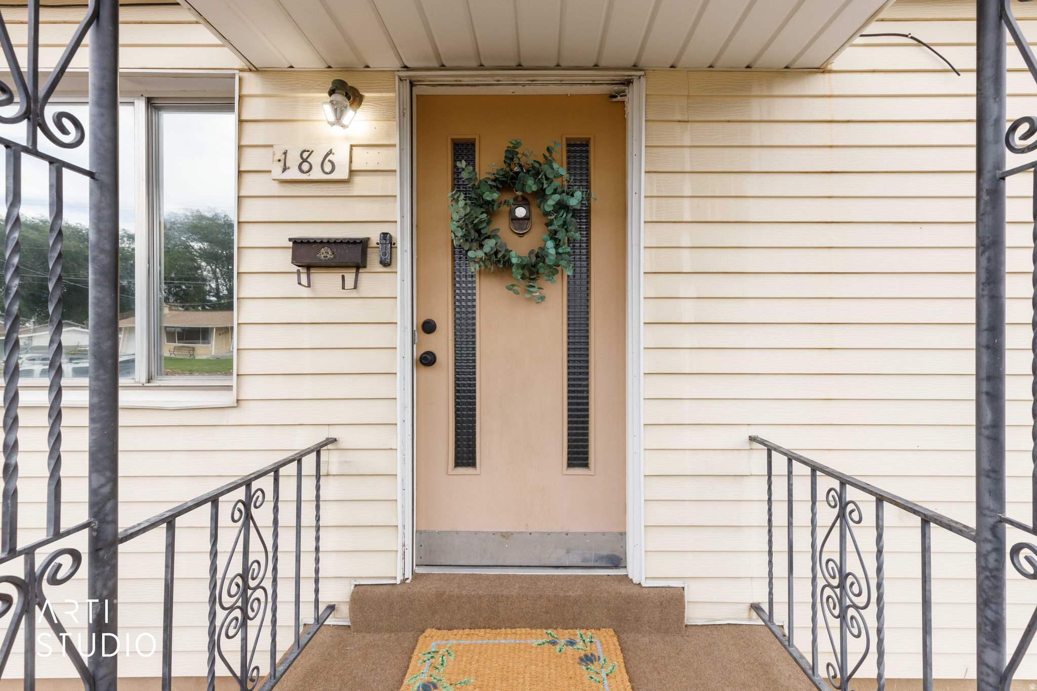 Cream-colored siding facade with a central entry door featuring vertical window inserts