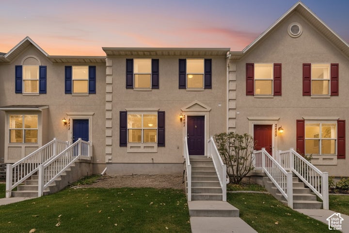 Stucco exterior with contrasting window shutters, front entry doors, and white railings