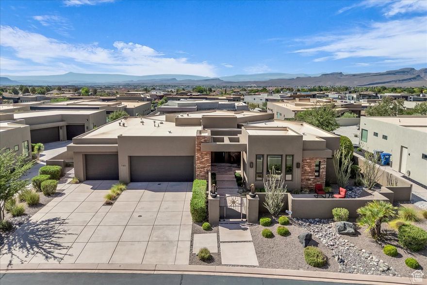 Welcome to your private sanctuary in the prestigious gated community of Palisades at Snow Canyon, embraced by the breathtaking backdrop of Red Mountain. This spacious 4-bedroom residence boasts soaring 10- and 13-foot ceilings that create an atmosphere of openness and elegance.  Designed for both relaxation and entertaining, the home offers two rear patios and a welcoming front courtyard. The living room is bathed in natural light from expansive windows and centered around a sleek electric fireplace, with a second fireplace warming the luxurious primary suite. The primary suite also features a spa-inspired shower with dual showerheads, custom shelving, and a generous walk-in closet. Every bedroom is complete with its own walk-in closet, ensuring ample storage. The chef's kitchen is a true showpiece, featuring a dramatic granite waterfall island, abundant cabinetry, dual ovens (electric and gas), a gas cooktop, and a hidden walk-in pantry large enough to accommodate a refrigerator with a water hookup. For modern convenience, the home is pre-wired for a Savant home automation system, includes two separate HVAC systems, two large capacity water heaters and offers a smart irrigation system accessible from a mobile app. The oversized 3-car garage is designed with function in mind, complete with a workbench, sink, metal shelving, wall-mounted organizers, and a ceiling-mounted storage rack perfect for keeping everything in its place. This exceptional property seamlessly blends comfort, style, and innovation in one of Southern Utah's most coveted locations. Don't miss the opportunity to make this remarkable home yours -schedule a private tour today and experience its beauty firsthand.