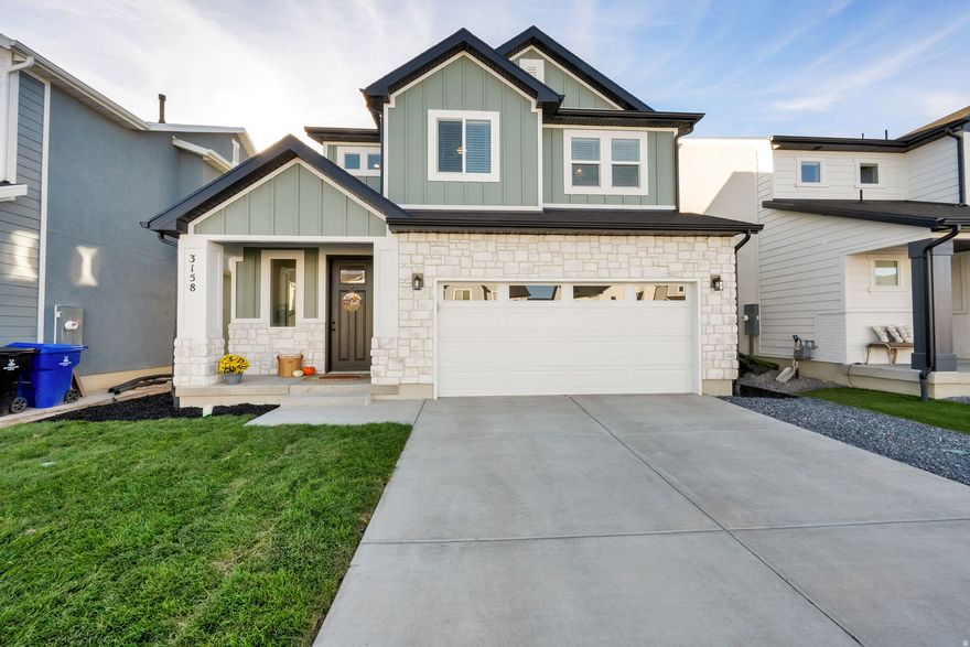 Nearly new, move-in-ready two-story home with a loft in the highly desirable Bayview at Shoreline community in Syracuse, Utah, offering 2,258 sq ft, 3 bedrooms, and 2.5 bathrooms with thoughtful upgrades throughout. The open-concept main floor features 9-foot ceilings, 8-foot doors, luxury vinyl plank flooring, abundant natural light from transom windows, and a long gas fireplace anchoring the living space. The kitchen is designed for both everyday living and entertaining with quartz countertops, floor-to-ceiling white shaker cabinetry, an oversized island with seating, gas range, built-in oven and microwave, touch faucet, composite granite sink, step-in pantry, and designer backsplash. Upstairs, the primary suite includes vaulted ceilings, a massive walk-in closet, double quartz vanity, oversized soaking tub, separate shower with cultured marble surround, and a private toilet room, while two additional bedrooms, a full bath, and a versatile loft provide flexible living space. The fully landscaped yard offers automatic sprinklers, partial fencing, and a covered patio, and the extra-deep, extra-tall two-car garage includes 220V EV charging, an upgraded electrical panel capable of supporting a hot tub, and ample storage. Additional features include recessed lighting, black hardware, quality window coverings, an owned water softener, and energy-efficient construction, with access to Shoreline amenities including a pool, pickleball courts, trails, playgrounds, and open space, all conveniently located near schools, parks, and commuter routes.