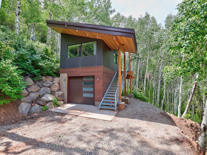 A rare modern retreat tucked into the aspens, just minutes from downtown Salt Lake City. Completed in 2023, this permitted structure sits on a secluded 0.59-acre wooded lot and blends steel, wood, and glass to create a bright, light-filled interior with vaulted ceilings and west-facing valley exposure. The property is located within Mount Aire Canyon in the Panorama area and includes its own private canyon setting, offering exceptional privacy and a true foothill experience. Enjoy quiet mornings, canyon views, and sunset evenings from the private deck, with additional room on the oversized lot for deck expansion or future square-footage growth, subject to approvals. An insulated lower level provides flexible garage or gear space. Smart-home features include automated lighting, motorized blinds, built-in sound system, and Nest thermostats with remote access. High-speed internet available. One water share allocated but not currently connected; blue PEX stub present (buyer to verify). Septic expansion and future improvements feasible.
