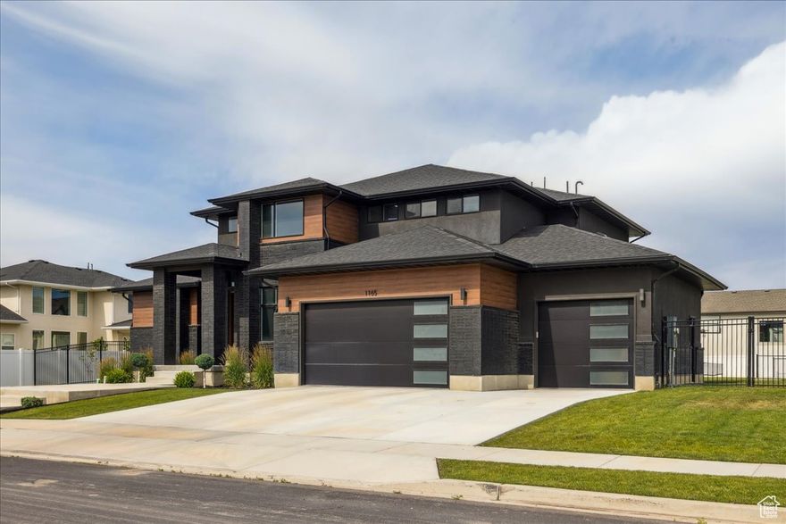This is a rare opportunity in the nearly sold-out Riverwalk luxury community. This modern, fully custom 2-story home sits on a private 0.4-acre lot and delivers unmatched high-end amenities inside and out.  The main floor showcases a designer primary suite with fireplace, spa-inspired bath, oversized shower, modern soaking tub, and a massive custom build out in the Primary closet. The kitchen features a butler's pantry with quartz, face-framed shelving, and built-in outlets. At the heart of the home, the expansive family room features soaring 18-ft ceilings and a dramatic floor-to-ceiling tile fireplace surround-a stunning complement to the chef's kitchen with quartz counters, custom cabinetry, and oversized laundry + mudroom.  Upstairs offers two bedrooms, a full bath, and an open loft and playroom that could easily be converted into a 3rd bedroom. The finished basement provides a private theater, gym space, guest suite, and abundant storage.  Step outside to enjoy a 40-ft wide covered patio, post-tension pickleball/tennis court, enclosed outdoor gym, Bullfrog spa, sauna, and fully fenced yard. Riverwalk residents enjoy access to a private pool, clubhouse, parks, and the Jordan River trail system-all for only $55/month.  With its striking exterior of modern black brick, low-maintenance wood accents, and professional landscaping, this Symphony masterpiece stands as a true statement of luxury, exclusivity, and lifestyle just minutes from the Point of the Mountain tech hub.