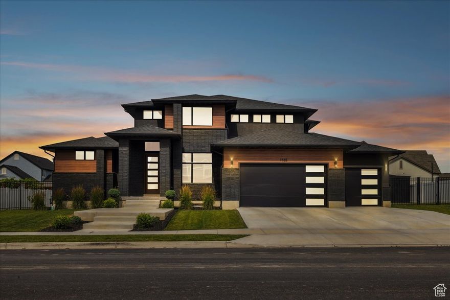 This is a rare opportunity in the nearly sold-out Riverwalk luxury community. This modern, fully custom 2-story home sits on a private 0.4-acre lot and delivers unmatched high-end amenities inside and out.  The main floor showcases a designer primary suite with fireplace, spa-inspired bath, oversized shower, modern soaking tub, and a massive custom build out in the Primary closet. The kitchen features a butler's pantry with quartz, face-framed shelving, and built-in outlets. At the heart of the home, the expansive family room features soaring 18-ft ceilings and a dramatic floor-to-ceiling tile fireplace surround-a stunning complement to the chef's kitchen with quartz counters, custom cabinetry, and oversized laundry + mudroom.  Upstairs offers two bedrooms, a full bath, and an open loft and playroom that could easily be converted into a 3rd bedroom. The finished basement provides a private theater, gym space, guest suite, and abundant storage.  Step outside to enjoy a 40-ft wide covered patio, post-tension pickleball/tennis court, enclosed outdoor gym, Bullfrog spa, sauna, and fully fenced yard. Riverwalk residents enjoy access to a private pool, clubhouse, parks, and the Jordan River trail system-all for only $55/month.  With its striking exterior of modern black brick, low-maintenance wood accents, and professional landscaping, this Symphony masterpiece stands as a true statement of luxury, exclusivity, and lifestyle just minutes from the Point of the Mountain tech hub.