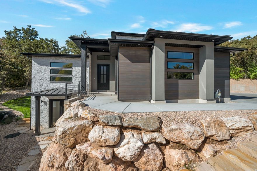 Open House Saturday 4/4 from 12:00-2:00 PM. Modern Two Story Home Loaded with Upgrades! This stunning modern home in South Ogden offers a functional layout with stylish finishes throughout. The spacious Great Room flows seamlessly into the Kitchen, where a full window wall and sliding glass doors open to a beautiful outdoor patio-perfect for indoor/outdoor living and entertaining. Enjoy sleek, modern designs, upgraded kitchen finishes, and a large walk-in pantry. The main laundry room is conveniently connected to the mudroom just off the garage.The Master bedroom is a true retreat, featuring a separate tub and shower, plus in-suite laundry hookups located in the large walk-in closet. Downstairs, you'll find a second Primary-like suite with its own walk-in closet and private laundry hookups- ideal for guests or multi-generational living.The lower-level living room includes a kitchenette and two separate entries-one of which is a private entrance perfect for a home office/business or potentially an ADU. Additional highlights: 3-car garage with an extra-deep 3rd bay,RV parking along the side of the garage. Terraced backyard with a lovely patio space, Don't miss your chance to own this feature-rich, move-in-ready modern home!