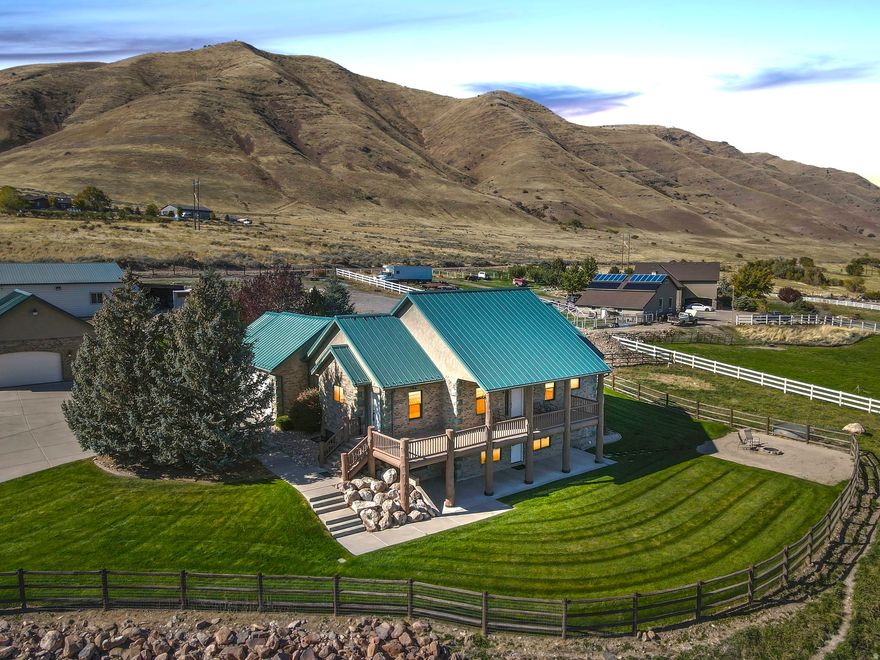 ** This home is being featured on "Real Estate Essentials" on ABC4, HULU+Live TV and Telemundo Utah** Video and a MUST SEE 3D virtual tour also available. If you've been looking for a home that is the complete package, you've found it! This serene 5 acre retreat offers breathtaking valley and mountain views, a beautifully remodeled open concept home, and the perfect blend of luxury and tranquility. Features include a chef's kitchen with quartzite countertops, a primary suite with dual walk-in closets, a finished basement with a dry bar and fireplace, a covered balcony above  and a covered porch/patio below both of which allow you to enjoy the enchanting views, and a fire pit that makes every moment feel truly magical.  Additional highlights: Separate kitchen pantry, 50 year metal roof, 7.97 shares of water, a well, an attached 3 car and detached 2-4 car garage, a custom cedar & redwood sauna, a 40 x 40 workshop, a 60 x 40 barn with 2 lean-to's, RV parking, various fruit trees, Bluegrass & Alfalfa ideal for grazing and a generator inlet. Homes like this don't come along often, don't miss the opportunity to make this dream home yours!