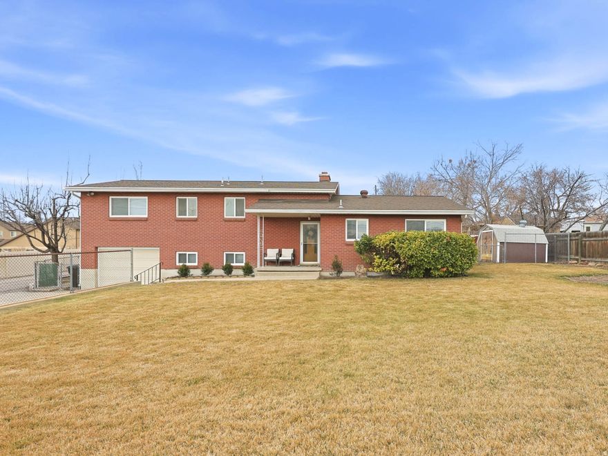 Solidly built and lovingly maintained by only two owners since 1959, this brick rambler in Taylorsville, Utah offers 3 bedrooms, 2 bathrooms, and a .33-acre lot that provides both space and privacy in Salt Lake County.  Original hardwood floors add character, while thoughtful updates throughout including fresh interior paint, upgraded windows (2020), furnace and A/C (2021), new water lines (2022), roof (2015), and water heater (2025) provide peace of mind. The spacious primary bedroom includes an ensuite bath, and the finished basement features a fireplace and separate backyard access.  The fully fenced yard includes a covered patio, dedicated RV or trailer parking, and pull-through access that allows you to enter, turn around, and exit facing forward. Elevated above street grade, the home enjoys added privacy and a natural sense of separation while maintaining convenient access.  Strategically priced, this property offers large lot living, privacy, RV parking, and a finished basement in a central Taylorsville location.