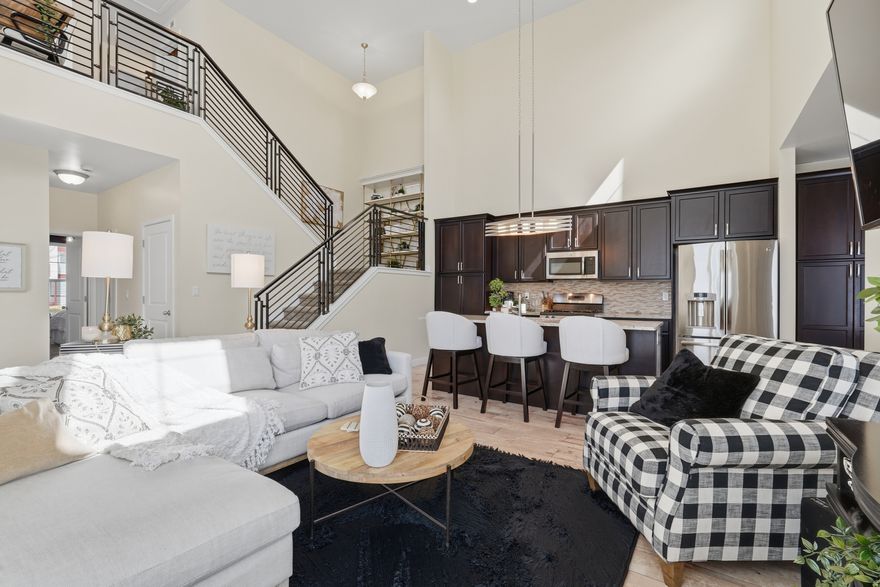 OPEN HOUSE, Saturday 11am-2pm! Rare main-level primary suite townhome located in the heart of the Daybreak community-offering one of the most sought-after and functional floor plans in the neighborhood. This beautifully designed 4-bedroom, 4-bath home spans approximately 2,788 square feet and blends open-concept living, a fully finished basement, and true low-maintenance convenience.  The main-level primary suite is ideal for single-level living and features an en-suite bathroom with granite double vanity, Euro-style walk-in shower, separate toilet room, walk-in closet with custom built-ins, and convenient laundry hookups.  The light-filled Great Room showcases two-story vaulted ceilings, oversized windows, and open sightlines to the kitchen and upper loft. The kitchen features granite countertops, center island, gas range, stainless steel appliances, custom backsplash, and modern lighting. The adjoining dining area opens to a private covered patio and fully fenced yard.  Upstairs, a loft provides flexible space for an office or sitting area. The finished basement offers a spacious family room, additional bedrooms and bathrooms, and generous storage room.   A rare feature of this home is exceptional laundry flexibility, offering up to three laundry hookup locations for added convenience.  Enjoy outdoor living with a covered patio, fully fenced yard, and HOA-maintained landscaping. The extra-length two-car garage provides ample parking and overhead storage.  Located just a short walk to Oquirrh Lake and Harmons in Daybreaks North Shore, residents enjoy Daybreak's unmatched amenities including fitness centers, pools, splash pads, tennis and pickleball courts, kayaking, trails, parks, and year-round community events. Fiber optic internet is included through the HOA.