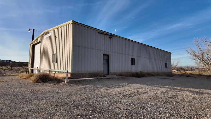 Large shop sitting on over 3.4 acres of land. The shop features an office space, a bathroom, a mezzanine, and a large roll-up door. Buyer to verify all information.