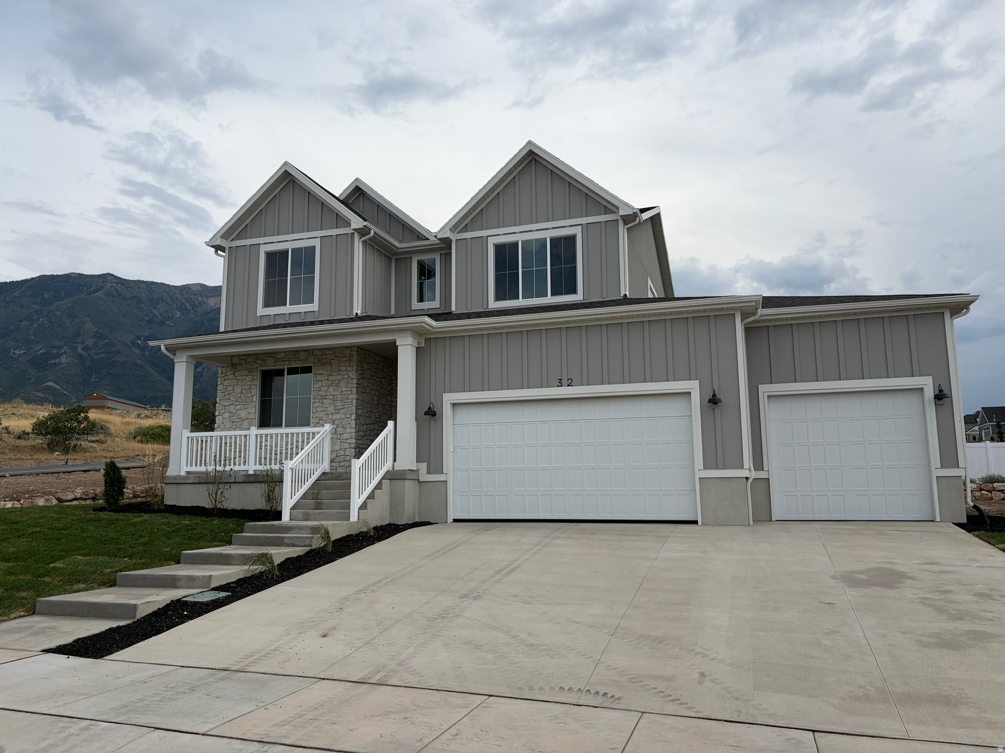 Contemporary two-story residence featuring board and batten siding with stone veneer accents