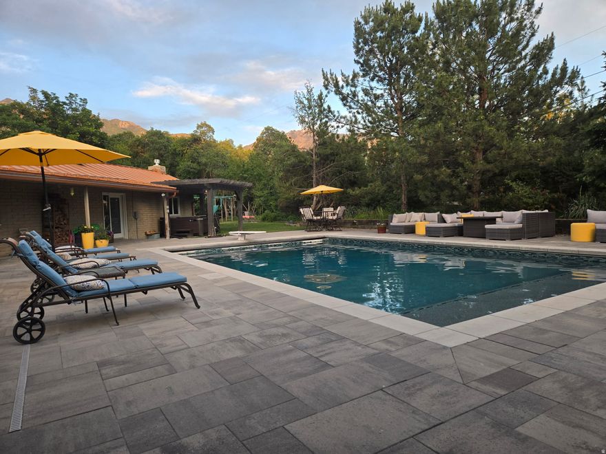 Delightful sprawling western ranch home all on one level. Reminiscent of the iconic "Cliff May" homes in Southern California. This house has several wings surrounding a fabulous pool and terraces. This is a premium .77-acre property.   Rustic block, wood timbers, windows everywhere and a striking metal roof enhance the character of this subtle mid-century architectural home. The central "great room" has extensive glass framing the amazing pool and secluded setting. The updated, ultra-modern kitchen has sleek cabinets, a cozy period fireplace and a quartz lined island bar. The amazing primary suite and great room have lovely fireplaces. A cozy den has nice built-ins. There are four great bedrooms. A spacious family room has a wet bar, two walls of windows and an adjoining courtyard patio with wooded ambiance. An exercise room, vaulted sunroom/den/studio and a huge, heated triple garage with storage complete the home. This place is loaded with southern light and has a feeling of open space. The views of the mountains are stunning. The park-like grounds have mature trees, beautiful scrub oak, a circular drive plus a separate drive to the garages. This is the best one level house you will find! The ultimate yard and setting. Quiet cul-de-sac!