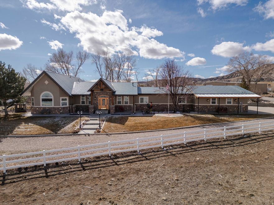 Custom Designed 4-Bed, 3.5-Bath Hillside Retreat on 5.9 Acres  Welcome to your dream home in Vernal, Utah, where custom design and natural beauty come together and offer stunning views of the valley and surrounding mountains. This horse and livestock property  includes riding arena, stalls, tack shed, self filling water troughs, and water hydrants. It is located just minutes from Flaming Gorge, Steinaker Reservoir, and Red Fleet State Park, it's a perfect base for access to world-class boating, fishing, river rafting, and hiking, while still being close to town amenities. The home features an open-concept layout filled with natural light, highlighted by large windows and a cozy gas fireplace in the main living area. The kitchen includes custom cabinetry, high-end appliances, and a spacious island-ideal for everyday cooking or entertaining. All four bedrooms are well-sized, with the owner's suite offering a walk-in closet, and en-suite bath with dual sinks and a walk-in shower. Outside, enjoy the many lounging areas, mature trees, and wide-open space to roam or expand. There's plenty of room for toys and storage with a 3-car garage and dedicated RV parking. This is a rare opportunity to own a thoughtfully designed home on acreage with room to grow, just a short drive from Vernal's shops, schools, dining, and endless outdoor recreation. Call today to schedule a private showing and experience this one-of-a-kind property.   Square footage figures are provided as a courtesy estimate only and were obtained from county records and appraisal.  Buyer is advised to obtain an independent measurement.  Buyer to verify any and all information provided via this listing.  Seller and Agent are related.  A.I./virtual staging was used on some photos.
