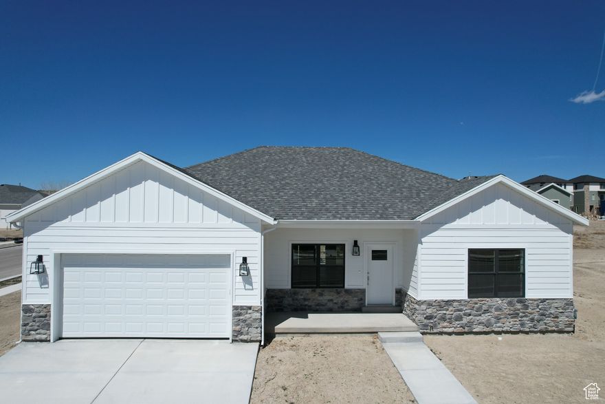This modern new construction home features a traditional style with a basement, boasting a sleek and contemporary aesthetic with white, gray, and chrome fixtures. The interior includes three bedrooms, two bathrooms, and a two-car garage, with both bathrooms featuring double sinks. The kitchen is equipped with all-new G.E. stainless steel appliances, Corian countertops, and a farm-style kitchen sink. Additional amenities include a pantry, closet organizers, and a special kitchen wastebasket cabinet. The exterior features a spacious back patio accessible from both the master bedroom and dining room and the home is plumbed for a water softener and has garage electric outlets for an electric vehicle charger.
