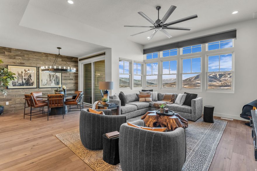 This mountain-modern retreat blends refined luxury with an effortless resort lifestyle. It is one of the few Deer Waters townhomes offering unobstructed sweeping views of the Jordanelle Reservoir and Deer Valley East Village from both levels. The main level has been professionally and beautifully designed for comfort and connection, featuring a spacious great room with gas fireplace, upgraded wood wall paneling, and elevated lighting throughout. An open dining area flows seamlessly to a view deck-ideal for morning coffee, sunset dinners, and relaxed gatherings. The chef's kitchen is both elegant and functional with gas cooktop, double ovens, pot filler, ice maker, upgraded cabinetry, a second sink and a generous pantry. Automatic blinds, a smart thermostat, and curated finishes add ease and polish. The main-level primary suite is a serene escape with double vanities, air-jet soaking tub, and spa-style steam shower. A flexible guest bedroom/office, half bath and laundry round out the upper level. The walk-out lower level is ideal for entertaining and extended stays, featuring a large family room with full wet bar, second washer/dryer, two guest suites, two baths, and a bonus room. A lower level patio walks out to expansive open space with playground and pickleball within walking distance. Additional highlights include two-zone HVAC, central AC, central vacuum with highly desirable baseboard sweeps, heat tape, tankless water heater, water softener, humidifier, radon mitigation system not to mention a finished two-car garage with epoxy floors, built-in storage, sink, and EV charger. Minutes from world-class skiing, hiking, biking, Jordanelle water recreation, and Salt Lake City International Airport, this inviting retreat is perfectly positioned for adventure-filled days and relaxed mountain evenings.