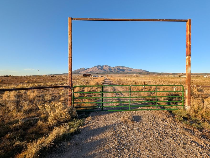 Beautiful 10-acre parcel with county road access and established utilities. Property features a 600' road-base driveway leading to a 50'x20' metal hay/equipment barn with attached horse/cattle corral. Power is in place with a 200 amp service, room for an additional 200 amp breaker, and a 30 amp RV hookup. A 100 GPM well with 60 GPM pump supplies three hydrants and a 2" main line with 17 gate valves for irrigation. Water wheel irrigates approx. 4 acres of alfalfa. Fully fenced with drill pipe fencing at entrance and field fencing around the perimeter. Electric fence setup in place. Survey and subdivision completed (not yet recorded). Zoned RR