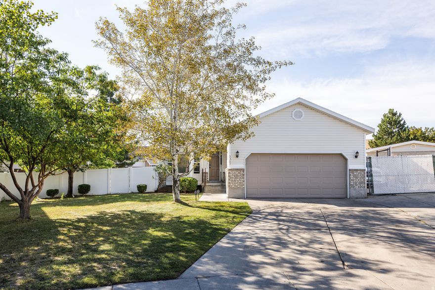 This lovely Kearns home-perched in a cul-de-sac that lends a bit of privacy in an established and tree-lined neighborhood-is bringing a good deal of charm and plenty of desirable features to the table. Having recently seen a remodel on the main level, the next lucky owners can reap the rewards of fresh paint, brand-new flooring, and updated cabinetry and counter tops in both the kitchen and bathrooms. A somewhat traditional layout is complemented by high ceilings and an abundance of natural light throughout, making it feel even more spacious than its 2100 square feet. The bright, spacious, and refreshed kitchen is connected seamlessly to the back yard via a set of sliding glass doors, leading out to a small deck that provides the setting for BBQs or dinners al fresco. With 5 bedrooms and 3 bathrooms, this is a home with room for everyone, and the lower level feels open and bright, thanks in part to large window wells-down here, you'll find a large living area, two of the aforementioned bedrooms, and a dedicated laundry room. The back yard is brimming with potential: plenty of lawn space and a pair of garden boxes lend themselves to fresh veggies and easy gatherings. A gated pad just next to the garage also means you've got room for your RV or boat. The best part? This area offers plenty of parks nearby, and the home is within walking distance of both the Kearns Olympic Oval and the Kearns Oquirrh Park Fitness Center. Translation: the good life is waiting for you on Alpine Flower Circle.