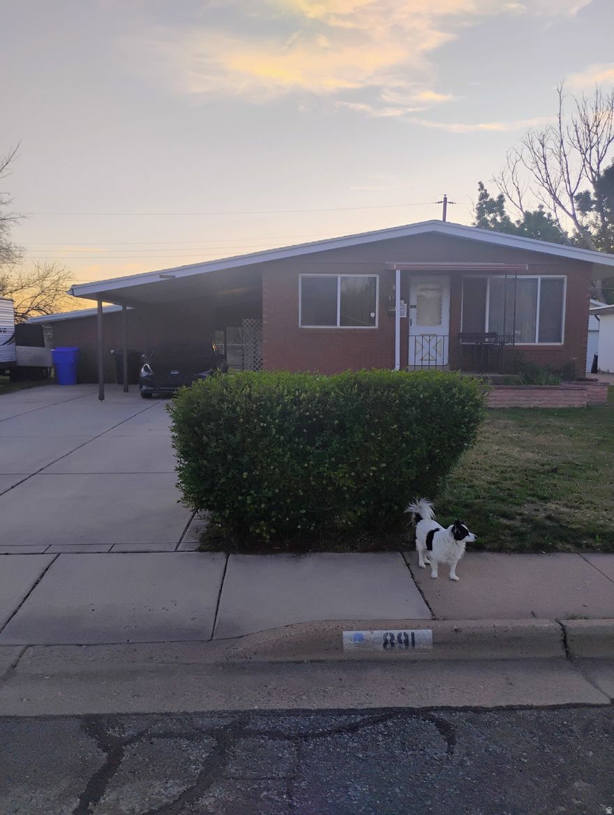 Spacious 5-bed, 2-bath rambler with 2,250 sq ft on a quiet street in a great neighborhood. Solid brick home with real hardwood floors upstairs and tons of potential to make it your own.  Fully fenced backyard, covered patio, and covered carport to add everyday comfort and convenience.  Prime location-just 3 minutes to the I-15 and about 10 minutes to Riverdale Road, with shopping, dining, and essentials close by.  Needs a little updating, but the space, location, and upside make this one a great find. Seller will not make repairs; property price and offered as-is;