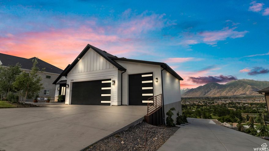Welcome to 3293 E Hawk Dr, where panoramic valley views greet you the moment you walk in. The open-concept main floor with large windows fills the home with natural light and showcases the stunning scenery. The master suite offers the same sweeping views, with a spa-like bathroom featuring Bluetooth speakers. The kitchen is designed for convenience with a pot filler above the stove and reverse osmosis water system. The home also features a versatile bonus room with Bose speakers, perfect for a movie theatre setup, gaming, or a second living area. The main-level garage includes two EV chargers, while the lower-level garage is spacious enough to accommodate an RV, in home gym, or extra storage space. The backyard, beautifully landscaped and spanning .62 acres, provides plenty of space to relax, entertain, and enjoy the breathtaking valley views. This home blends comfort, function, and unmatched scenery in a highly sought-after Spanish Fork location.  Square footage figures are provided as a courtesy estimate only and were obtained from County records.  Buyer is advised to obtain an independent measurement.