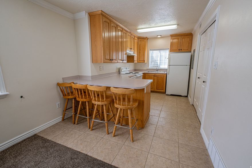 One of the best-priced condos in Utah County and in a great little community. Located a short distance from shopping, schools, and I-15. Plenty of parking within the community, with 2 assigned parking spots (One covered and one uncovered). The quiet HOA has a spacious pavilion/picnic area and playground as well as grass space. The owners have put great care into maintaining this condo. Easy to Show. Barstools are included. Buyer and Buyer's Agent to verify all information.