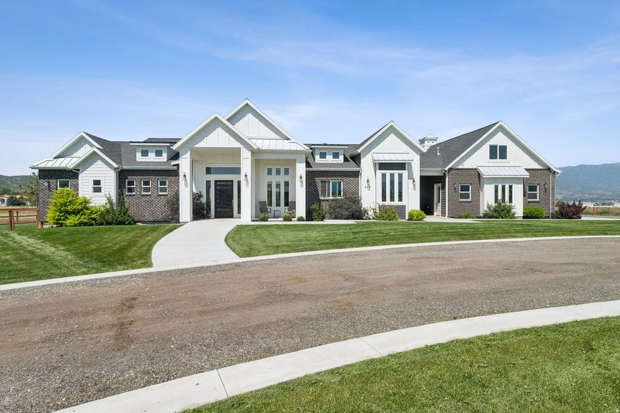 Welcome to an extraordinary 6.11-acre estate where refined luxury meets wide-open possibility. Perfectly positioned in the heart of Heber City and framed by breathtaking, unobstructed views of majestic Mount Timpanogos, this rare offering blends sophisticated residential living, equestrian charm, and approximately 3 acres of Industrial zoning-all within an Enterprise Zone offering potential future development flexibility.  The modern, architecturally designed residence is both grand and inviting, thoughtfully curated for today's luxury lifestyle. Featuring three expansive en-suite bedrooms, each offers privacy and comfort reminiscent of a boutique retreat. A spacious private gym-already plumbed for an additional bath-provides the opportunity to create a fourth en-suite sanctuary if desired. A beautifully appointed office with custom built-ins, an elegant family and game room with kitchenette, oversized pantry and storage spaces on both levels, a refined powder bath, designer mud/locker room, and an expansive laundry suite ensure every modern convenience has been considered.  The oversized four-car heated garage offers ample space for vehicles and recreational toys alike, while the partially completed up the stairs ADU above provides an exciting opportunity for customization-ideal for guests, extended family, or private quarters.  Outdoors, the estate is equally captivating. Designed for both equestrian enthusiasts and those dreaming of a private garden estate or mini farm, the property includes irrigation infrastructure, and water shares available for separate purchase.  This is more than a home-it is a lifestyle property offering elegance, versatility, and future opportunity in one of Utah's most scenic settings.