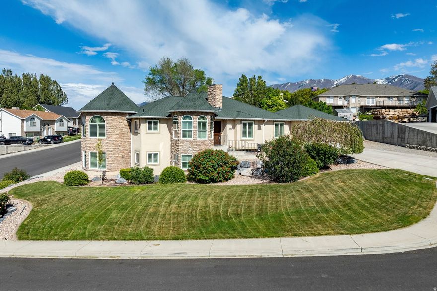 Spacious home on a corner lot with a legal basement apartment and sweeping mountain and Utah Lake views. The main level offers a functional layout with a primary suite, additional bedrooms, a family room with fireplace, and a kitchen with granite countertops, tile flooring, and peninsula seating. Plantation shutters, crown molding, and quality finishes are consistent throughout. The family room opens to a Trex deck, and the turret sitting area provides excellent natural light and views. The daylight walk-out basement features a city-approved, legal rentable apartment with private entrance, full kitchen, laundry, and separate gas meter. Both levels are configured with three bedrooms, two bathrooms, and their own kitchens and laundry areas, allowing for multi-generational living or rental income. Additional features include triple-pane argon windows, a high-efficiency HVAC system, two commercial-grade water heaters, and a newer 50-year roof. The fully fenced backyard includes mature landscaping, a garden, fruit trees, rock retaining walls, RV parking, a shed, and a quiet cul-de-sac setting. Convenient access to I-15, shopping, dining, and trails.