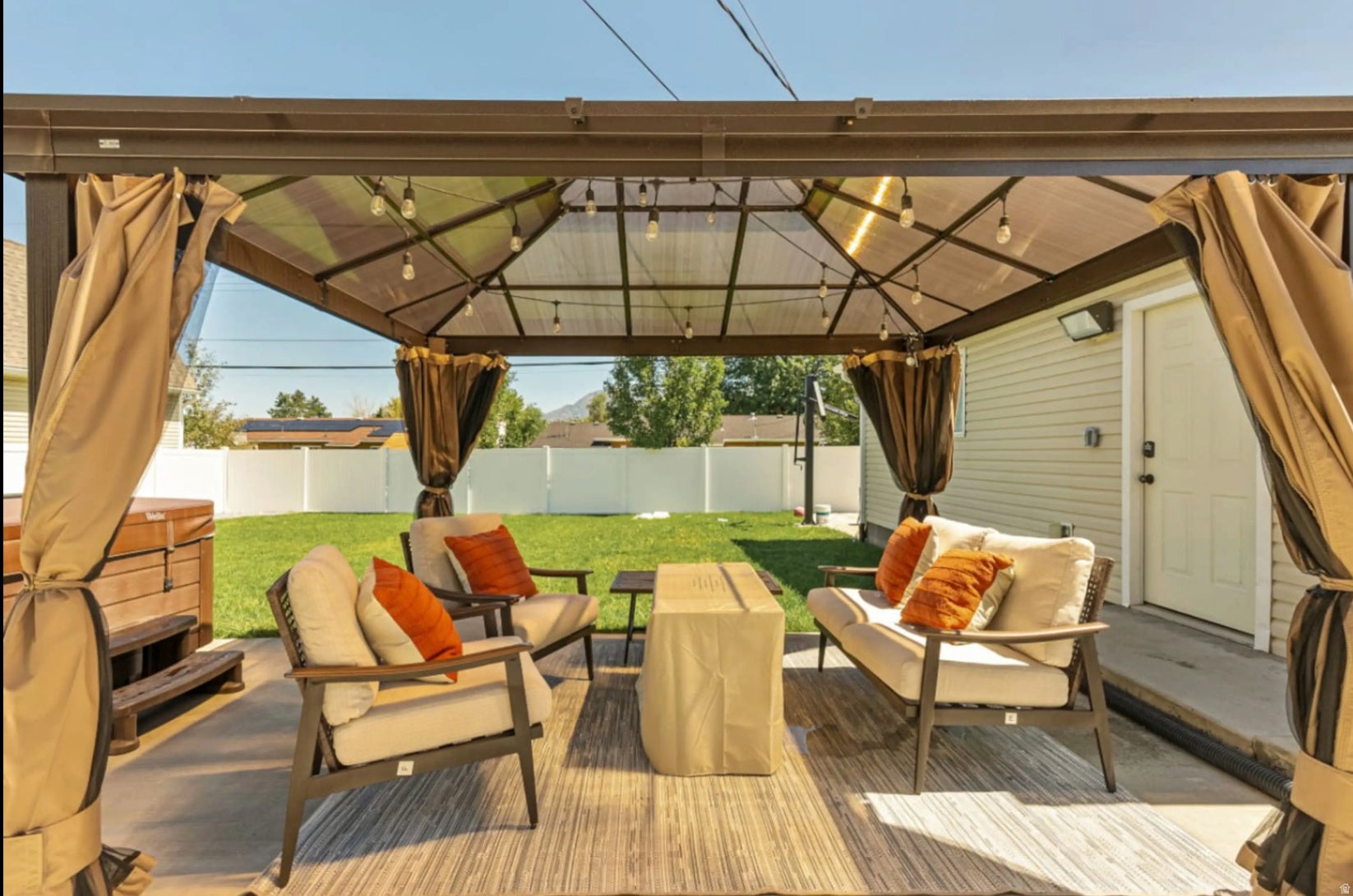 Patio featuring a permanent gazebo structure with a translucent roof and string lighting