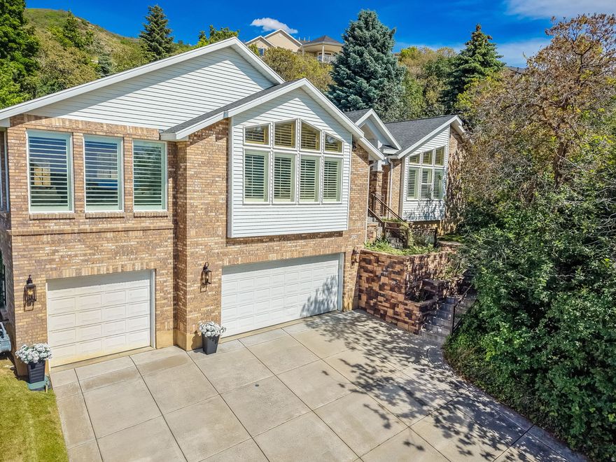 Fully renovated and move-in ready, this Bountiful stunner sits on over half an acre at the end of a quiet cul-de-sac - offering luxury finishes, designer details, and incredible views in one of Davis County's most sought-after neighborhoods. Tucked into an established community with a highly regarded school district, easy canyon access, and quick connections to Salt Lake, this home delivers lifestyle and location in equal measure. Step inside to 14-foot vaulted ceilings, designer chandeliers from Anthropologie and Neiman Marcus, and a chef's kitchen built to impress - featuring a massive 5' x 10.5' quartz island, 9-foot custom cabinetry with hidden paneled Bosch dishwasher and integrated pantry, Viking double ovens, a 48" 7-burner gas cooktop, Bosch refrigerator, and a hidden drawer microwave. Every cabinet includes custom rolling drawers. The great room invites you in with a custom stone gas fireplace, built-in bookshelves, and an 85" Samsung Frame TV (included). Retreat to the spa-like primary en-suite with a large shower and deep soaking tub. Downstairs, a fully renovated basement kitchen with granite countertops and full-size appliances is perfect for entertaining or multigenerational living. Premium extras: central vac, heated driveway and front steps, dual water heaters, dimmer switches, gold hardware, and new lighting throughout. Renovated 20232024: full kitchen remodel, all bathrooms, new flooring (LVP hardwood, carpet, wood stair treads), interior paint, electrical updates, and basement kitchen. Included: Washer/dryer and all appliances (new in 2023), Samsung Frame TV, family room furniture, patio dining set, sectional, swing, fire pit table, office desk, basketball standard, and shed. Basement sectional negotiable. Don't miss your chance to own this turnkey Bountiful gem with views, finishes, and location to match.