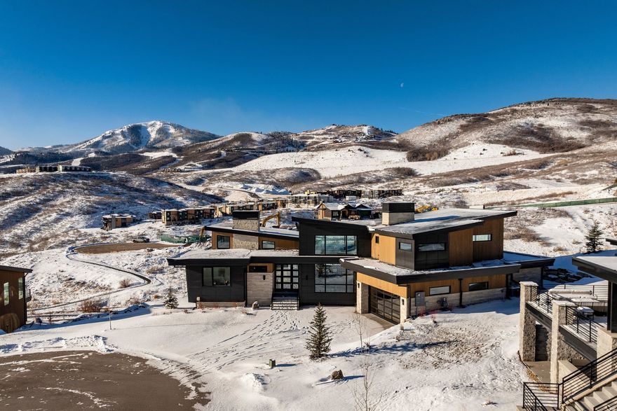 Step into elevated mountain living at 1717 Centaur Court in SkyRidge, a newly built 5,361 sq ft modern mountain retreat designed by Moxie Design and crafted by Aecum Development. This 6-bedroom, 8-bathroom sanctuary was thoughtfully designed to embrace expansive views of Mayflower, Jordanelle Reservoir, and Deer Valley East ski runs through walls of glass in every room. Created for year-round living and entertaining, the home features a chef's kitchen with cabinet-paneled appliances, a kitchen island with custom milled waterfall edge, dual dishwashers, and custom cabinetry, all flooded with natural light. Expansive gathering spaces flow seamlessly to view-filled terraces, while the private primary suite crowns the upper level with its own rooftop patio facing hundreds of acres of ski terrain. The floor plan offers ultimate flexibility: two bedroom suites on the main level (one perfect as a home office), and three additional suites downstairs alongside a large game room with a wet bar. Details such as a heated driveway, custom lighting, and refined finishes elevate the sophistication of the home. As part of the premier SkyRidge community, residents enjoy direct access to the new Deer Valley East expansion, complete with a planned resort base offering dining, ski shops, and shuttle access. Outdoor adventure awaits just minutes away with boating at Jordanelle, equestrian facilities, golf, and miles of scenic hiking and biking trails-all within easy reach of Park City, Salt Lake City, and the Heber Valley. Purposefully priced below comparable homes in the community, this residence delivers luxury, adventure, and serenity-the ultimate mountain lifestyle.