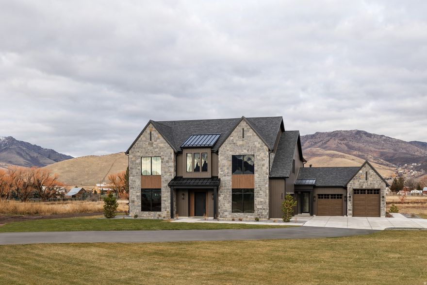 Experience refined mountain living in this stunning home at SAGE, now move-in ready. Set on a private 3-acre lot, this 4-bedroom + bunk suite, 5.5-bath residence spans over 4,400 square feet of thoughtfully designed luxury and craftsmanship. Every detail reflects elevated taste-from the Brizo polished nickel and luxe gold fixtures to the dark oak cabinetry paired with aged brass hardware. The chef's kitchen features a full Signature Kitchen Suite appliance package, including a 48" six-burner gas range, fridge/freezer columns, and Scotsman ice maker. Elegant quartz countertops, glossy ceramic backsplash, and soft brass pendants create a warm and timeless atmosphere. The primary suite is a retreat of its own, offering a spa-like bath with matte porcelain floors, soaking tub, and custom gray-brown cabinetry. Upstairs, a bunk room and four additional bedroom suites each feature designer tile, Delta and Brizo plumbing, and curated lighting finishes. Enjoy the seamless connection between the great room, dining, and covered outdoor living spaces-perfect for entertaining or taking in the surrounding views. A four-car garage, expansive mudroom with custom built-ins, and walk-in pantry complete this one-of-a-kind residence. Discover where craftsmanship meets comfort at SAGE Lot 3-ready for immediate occupancy.