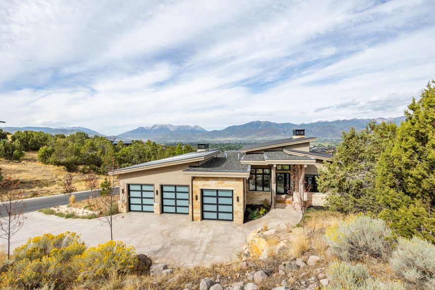 Experience contemporary mountain living in this 5,391 sq ft home tucked within the private gates of Red Ledges. Designed with clean lines and natural finishes, this residence combines modern sophistication with timeless mountain charm. The spacious layout features 5 bedrooms and 7 bathrooms, including a luxurious master suite. A gourmet kitchen with premium appliances, custom cabinetry, and an oversized island anchors the home, while the open living areas showcase soaring ceilings, and inviting spaces for gathering. Expansive outdoor living includes a covered patio, natural landscaping, and sweeping mountain views, creating the perfect setting to relax or entertain. Red Ledges residents enjoy world-class amenities, including golf, swimming, tennis, fitness, and dining, with a required Golf Park or Lifestyle membership available with this property. Ideally located just minutes from downtown Heber and within easy reach of Deer Valley world-class skiing, this home offers the ultimate blend of luxury and mountain living. Schedule your private tour today.