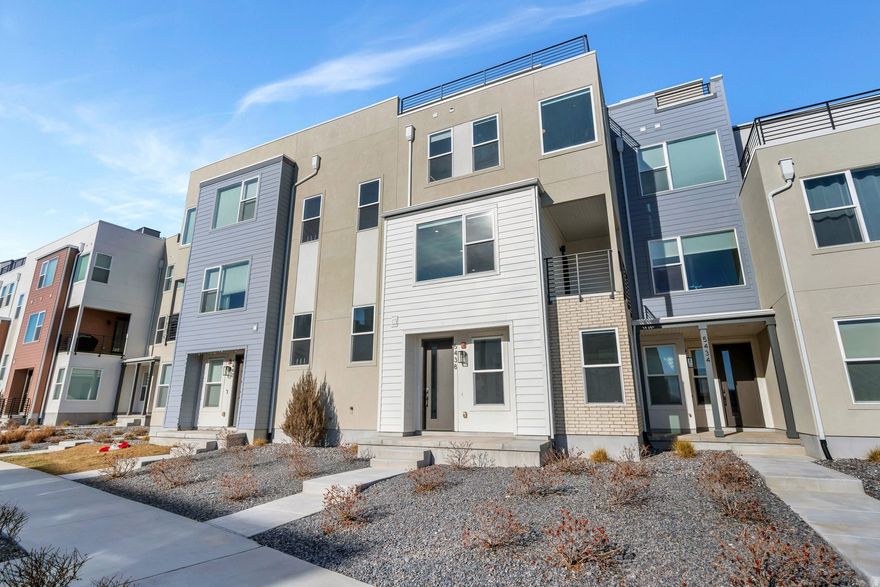 Stunning 4-story townhouse in the heart of Daybreak, designed to impress from every level. Enjoy seamless indoor-outdoor living with a living room balcony and an expansive rooftop terrace, perfect for entertaining or taking in sweeping views of the south end of the valley. Sunlight pours through large, south-facing windows that wrap the home, creating bright, airy spaces throughout.  The kitchen is light and inviting, featuring stainless steel appliances and a clean, modern feel. Retreat to the spacious, light-filled primary suite, complete with a spa-inspired primary bath showcasing a walk-in shower with seating bench and sleek black hardware. Additional highlights include an attached 2-car garage and thoughtful design details that blend style, comfort, and functionality.  Ideally located near the TRAX station, the new Bees stadium, and Ewok Park, this home offers unbeatable access to recreation, entertainment, and easy commuting, all while enjoying elevated living in one of Daybreak's most desirable settings.