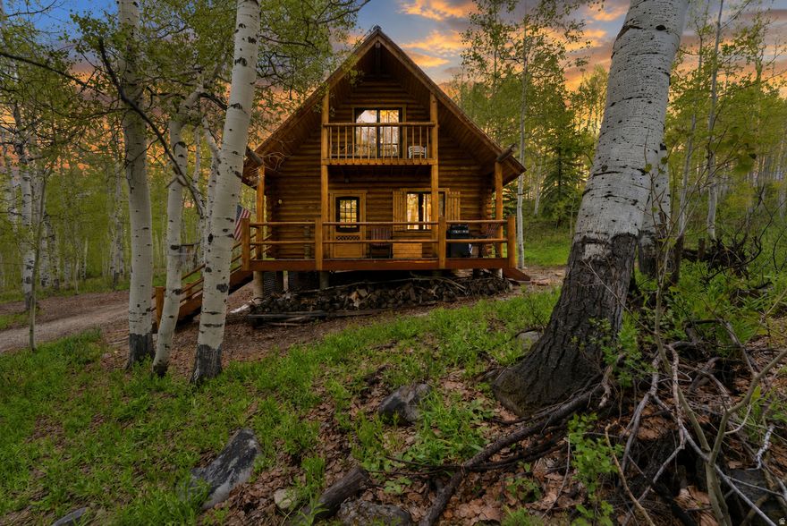 Charming furnished A-frame log cabin tucked in the woods of Timber Lakes Estates on .81 acres, offering the perfect mountain escape for gathering with friends & family year-round. This cozy retreat sleeps up to 14 in beds and features a main-level primary bedroom, spacious loft with private balcony, a 3-piece bath, closet storage, and a well-designed floor plan full of rustic cabin charm. Warm wood interiors and a wood-burning stove create the ultimate mountain atmosphere. Unfinished space beneath the cabin offers potential for installation of a furnace or additional heat source, creating possible FHA/VA financing eligibility, which Sellers may consider with an acceptable offer. Also available via a separate bill of sale: 2013 Polaris RZR 800 EFI, street-legal, fuel-injected, approx. 4,700 miles ($5,700), plus 2018 Charmac cargo trailer ($3,500). Located in Timber Lakes, a private guard-gated mountain community just 7 mi east of Heber City with year-round access, maintained roads/utilities, private Uinta Nat'l Forest access, and proximity to Heber Valley & Park City recreation, dining, skiing, boating, golf & ATV-ing, world-class fishing, & snowmobiling!