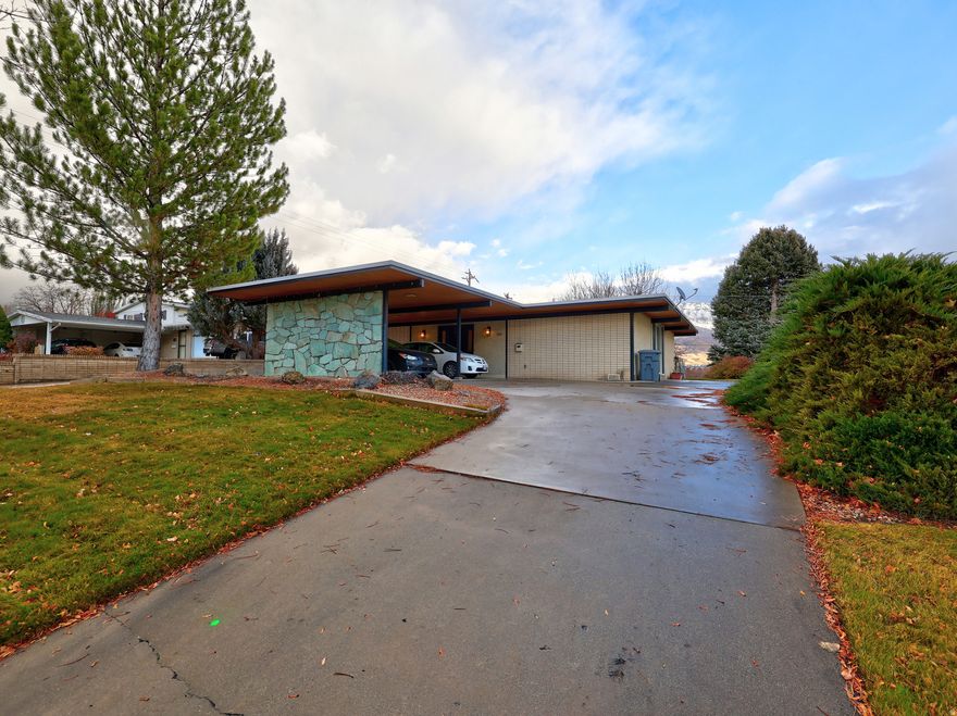 Come see this quaint home. Enjoy breathtaking views and entertainment-ready back yard of this classic, mid-century single level living California-style ranch home. A rock two-way fireplace romanticizes both the living room and dining area. A circular driveway slides under the porte-cochere-style carport where stylish brick banishes outside noises, offering easy access to 100 East. Enjoy fruit trees in the picturesque back yard plus a mature English walnut tree, along with the stream that runs through the yard and views of Mount Timpanogos. Enjoy the sunrise each morning and the shaded backyard in the afternoon. Upgrades include a  replaced roof, new heater and A/C and new ducts. Squarefootage per county records. Buyer to verify all.