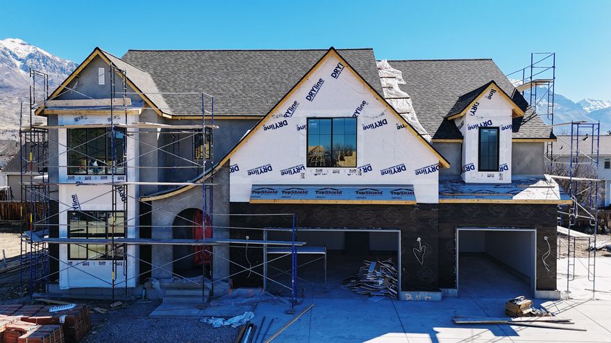 Our newest Neighborhood in Orem, Belmont West with the Avery Floorplan.  This stunning Tudor two-story home features a breathtaking two-story family room with an abundance of windows, allowing you to bask in natural light and enjoy spectacular views. The home boasts a luxurious butler's pantry with custom cabinetry, a commercial gas range, and a built-in twin fridge/freezer combo-perfect for entertaining and everyday living .Quartz counter tops, with designer touches throughout and so much more.. Basement entrance for future ADU  and it is Scheduled for completion Mid May, this home is a must see!