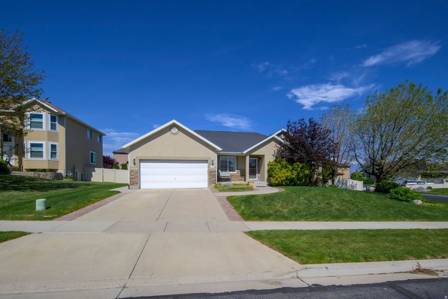 Beautiful rambler in Saratoga Springs with a fully finished basement and nearly 3,000 sq ft of living space! This well-maintained home features an open-concept layout, spacious kitchen with gas range and large island, hardwood flooring, and bright dining/living areas filled with natural light. The basement is fully finished with a massive second family room, additional bedrooms, recessed lighting, built-in shelving, hidden storage, and an indoor slide/play area. Separate basement entrance offers added flexibility and convenience. Enjoy the fully enclosed backyard with vinyl fencing, garden boxes, automatic sprinklers, and a large storage shed. Located on a quiet cul-de-sac corner lot near parks, schools, and shopping with beautiful mountain and Utah Lake views.