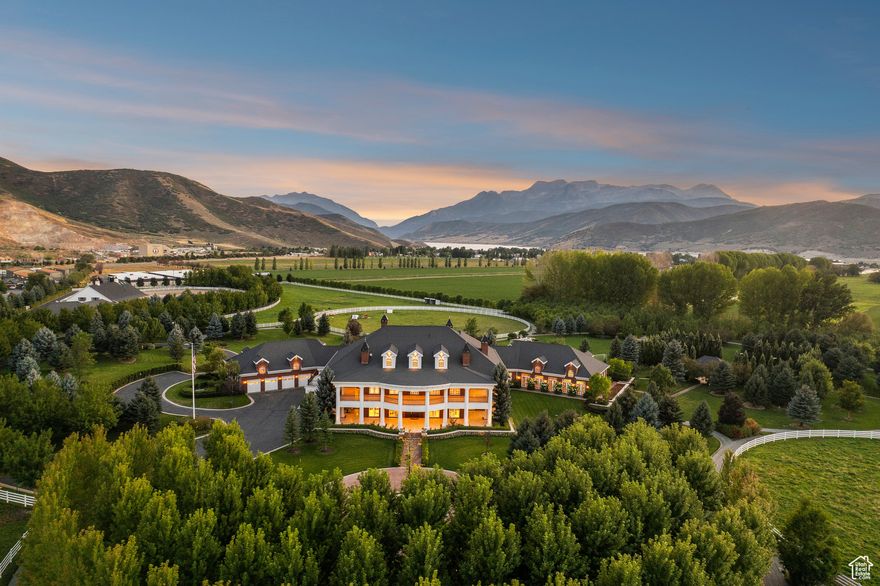 Welcome to Camelot, Utah's Only Parisian Modern Estate  Set on 27 manicured acres, Camelot is a sanctuary where Parisian Modern design meets mountain majesty. In 2023, the 24,000-square-foot residence was completely transformed, reimagined with limestone facades, bespoke millwork, imported stone, and walls of glass that dissolve into sweeping views of the Wasatch Mountains and Heber Valley.  The interiors feel like a gallery of light and proportion, with expansive salons, intimate sitting rooms, chef-inspired kitchens, and spa-level baths balancing timeless artistry with contemporary ease.  The grounds unfold like a private resort: an Olympic indoor pool shimmers at the center, while private tennis courts, a baseball diamond, and a soccer field provide endless leisure. For equestrian living, an expansive barn anchors elite jumping and dressage arenas designed by Wayne Gregory, crowned with a two-bedroom suite above.  Camelot is more than a home. It is a generational masterpiece, a once-in-a-lifetime estate that defines elegance in Utah.
