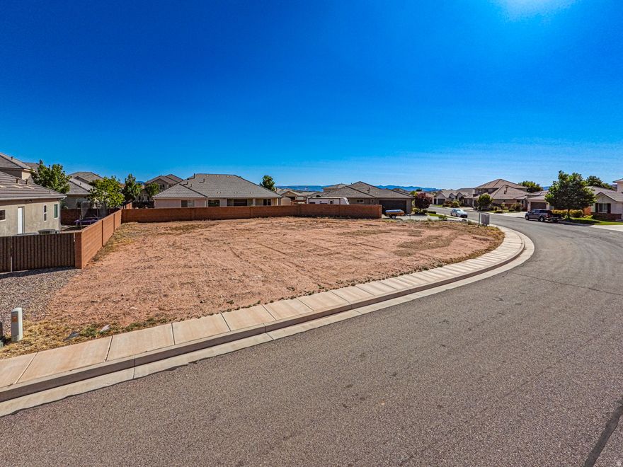 Build your dream home in the highly sought-after Steeplechase at Washington Fields subdivision-with no HOA fees! This just under 1/4 acre lot is flat, pad-ready, and ideally situated on a quiet street with a desirable north-facing orientation and views of Pine Valley Mountain. One of the standout features of this property is its impressive 133.66' of frontage-one of the largest in the subdivision-offering ample space for an oversized garage, shop, or RV parking. The lot is fully improved with block walls on three sides (a $12,760 value), paved streets, curb, sidewalk, and a cluster mailbox already in place. Utilities are ready to go, including natural gas, culinary city water, sewer, and Dixie Power electric-all stubbed to the lot. Plus, the Washington County Water Conservancy District impact fee has already been paid, saving the buyer $17,266 (and rising annually). Dixie Power is known for some of the lowest residential electric rates in the country, adding long-term savings. Located within the desirable Crimson Cliffs school district and within walking distance to schools, this property also offers convenient access to medical services, shopping, dining, and more. And with St. George Regional Airport less than 15 minutes away, you'll enjoy both comfort and connectivity. Now offered at $345,000, this is a rare opportunity to secure a premium, build-ready lot in one of Washington's most desirable communities.