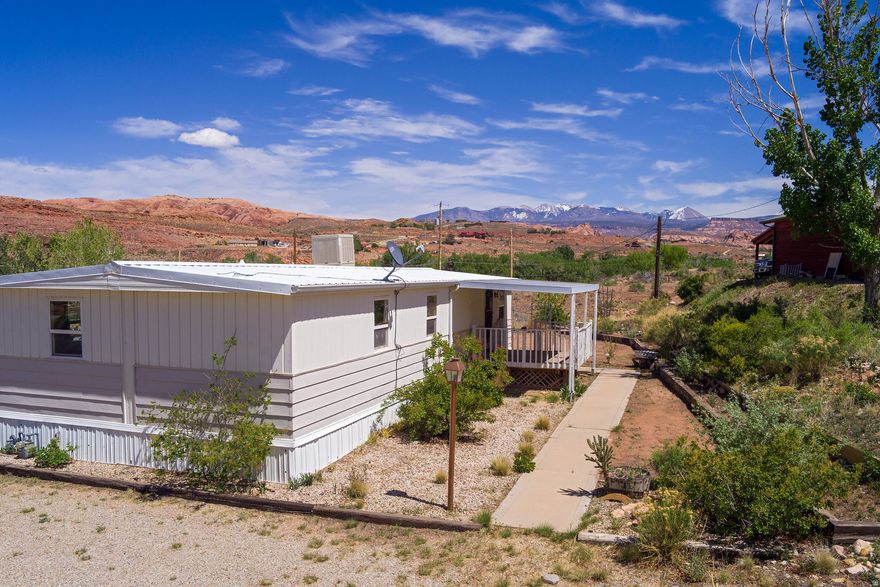 Welcome to your affordable retreat! The property will qualify for a conventional loan. Please contact listing agents for lender information. This cozy 2-bedroom, 1-bath home sits on a generous .53-acre lot, offering breathtaking views of the majestic La Sal Mountains. Perfectly positioned above the valley floor, this property provides a serene escape with two covered decks where you can relax and soak in the picturesque surroundings. Step inside to discover a welcoming atmosphere featuring a nice kitchen equipped with ample cupboard space and a gas range. This home is also set up for a pellet stove, ensuring warmth and comfort during the colder months. A sturdy shed provides space for your tools and outdoor gear. The property has the potential to build another home while utilizing the existing residence as an Accessory Dwelling Unit (ADU). Don't miss the opportunity to make this property your own, whether you're looking for a primary residence, a vacation getaway, or an investment opportunity.  Square footage figures are provided as a courtesy estimate only and were obtained from county records.  Buyer is advised to obtain an independent measurement.